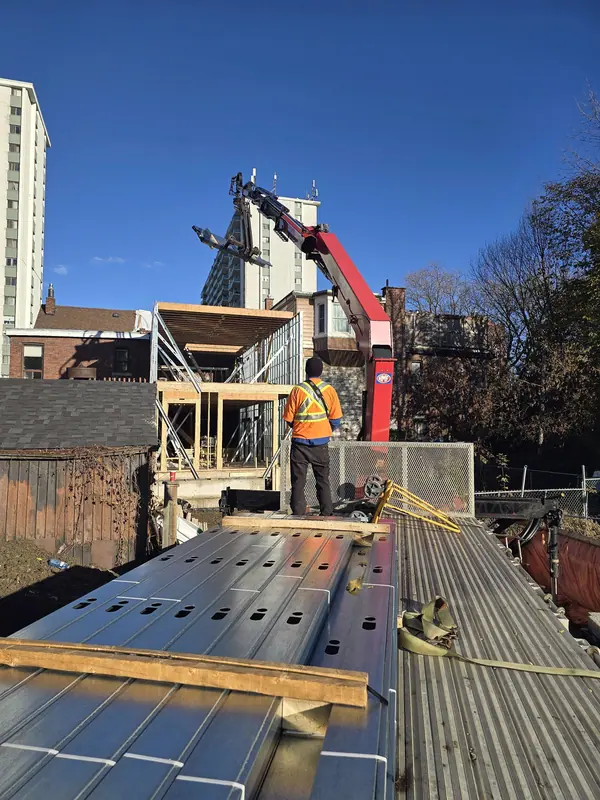 Crane delivering steel studs rooftop