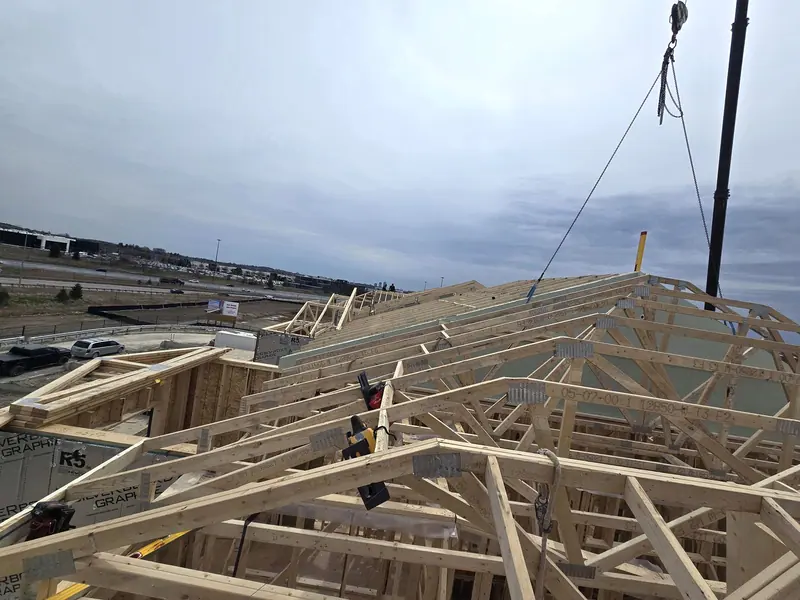 Crane installing roof trusses townhomes