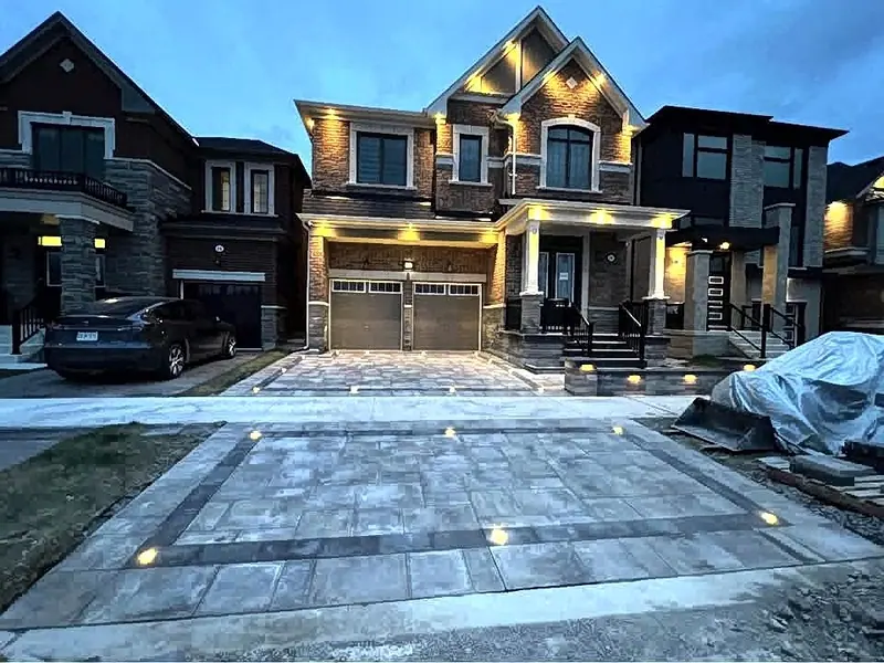 Finished custom home interlock driveway lighting